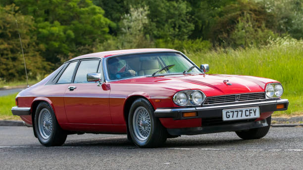 Stony Stratford,UK - June 4th 2023: 1989 red JAGUAR XJS  classic car travelling on an English country road.
